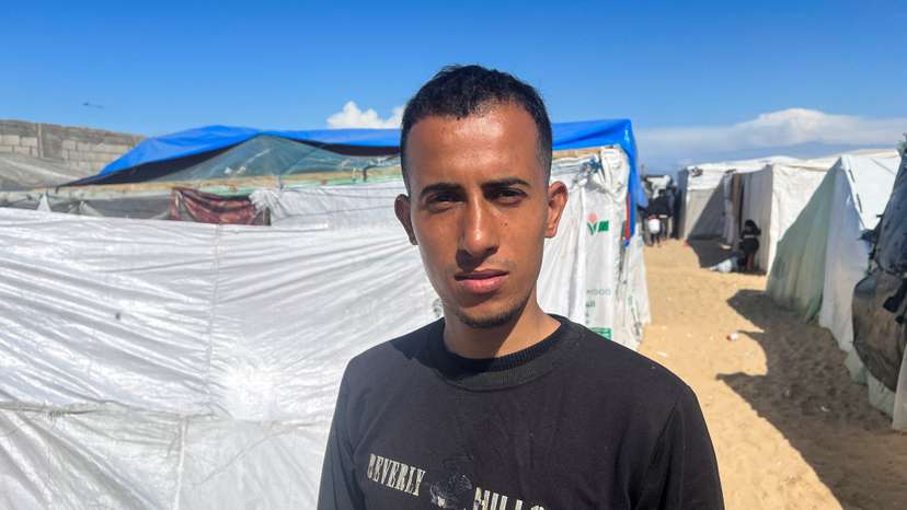 Displaced Palestinian man Youssef Shalha, who is engaged to Bisan Badah, looks on outside his tent in Rafah