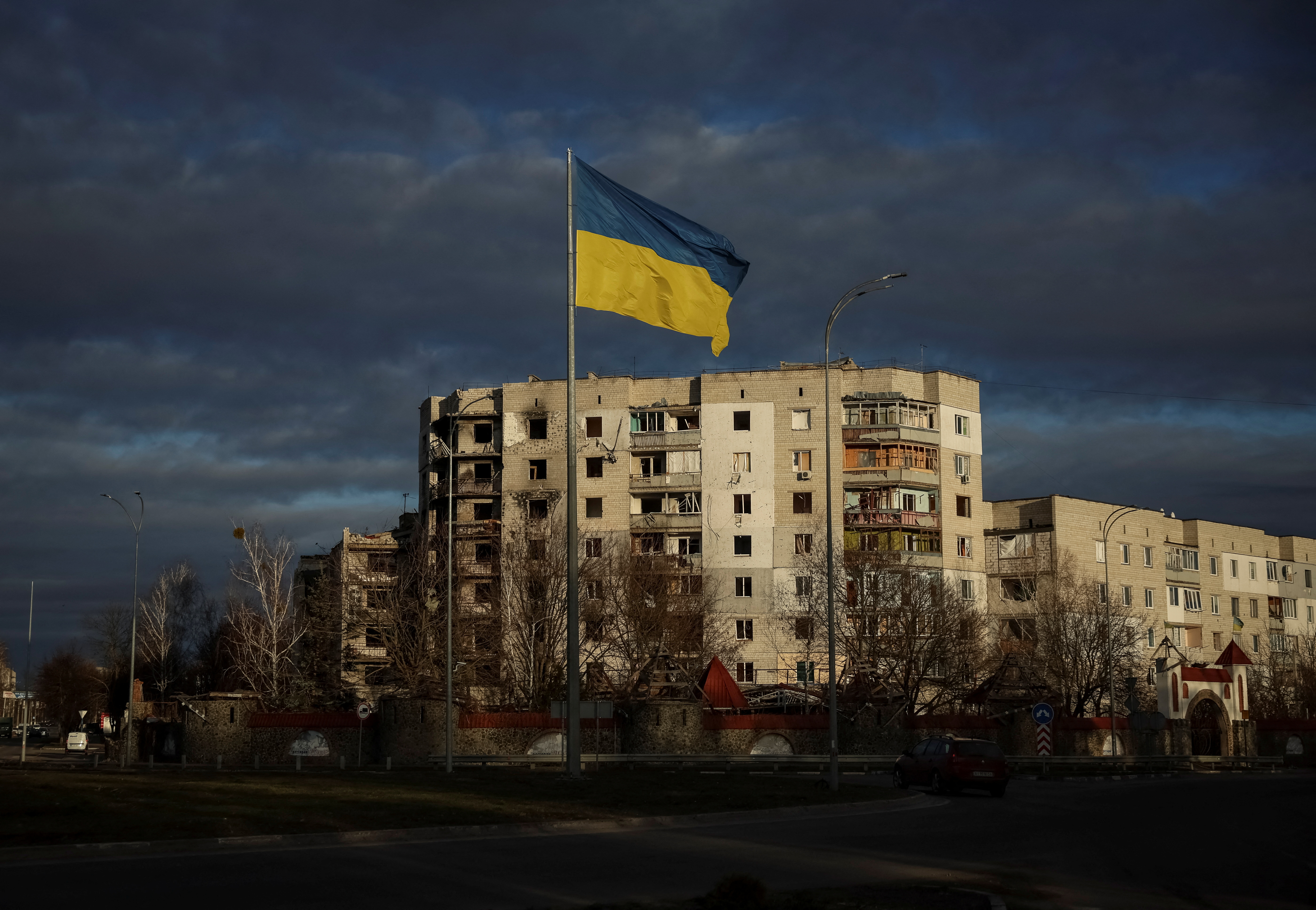 FILE PHOTO: Ukrainian national flag flies near buildings destroyed by Russian military strike in Borodianka
