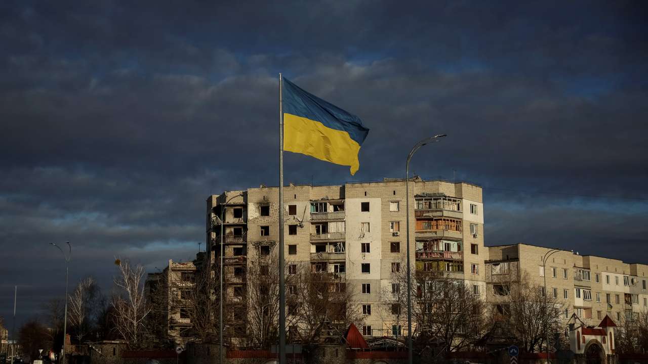 FILE PHOTO: Ukrainian national flag flies near buildings destroyed by Russian military strike in Borodianka