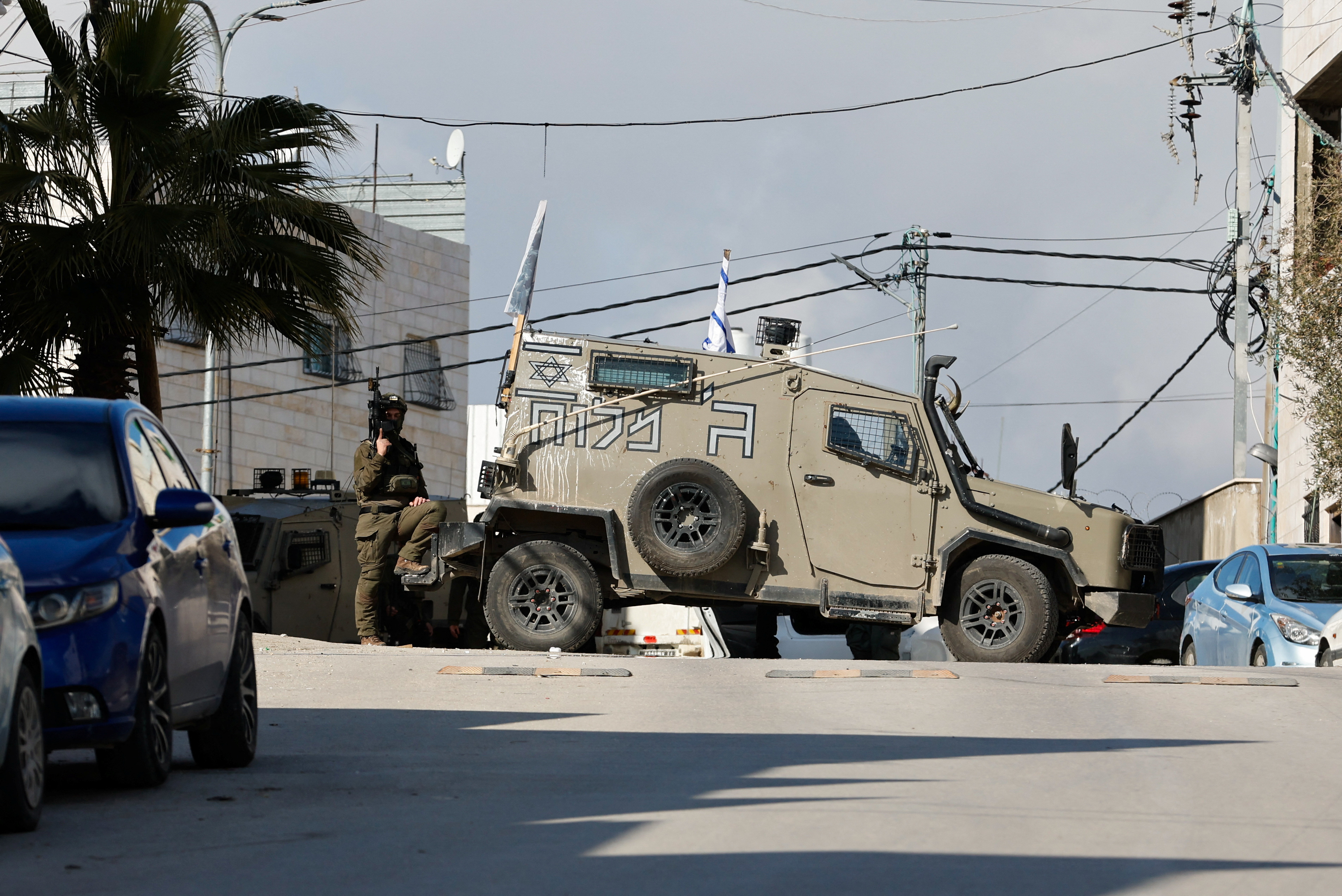Israeli troops stand guard near a shooting scene in Hebron