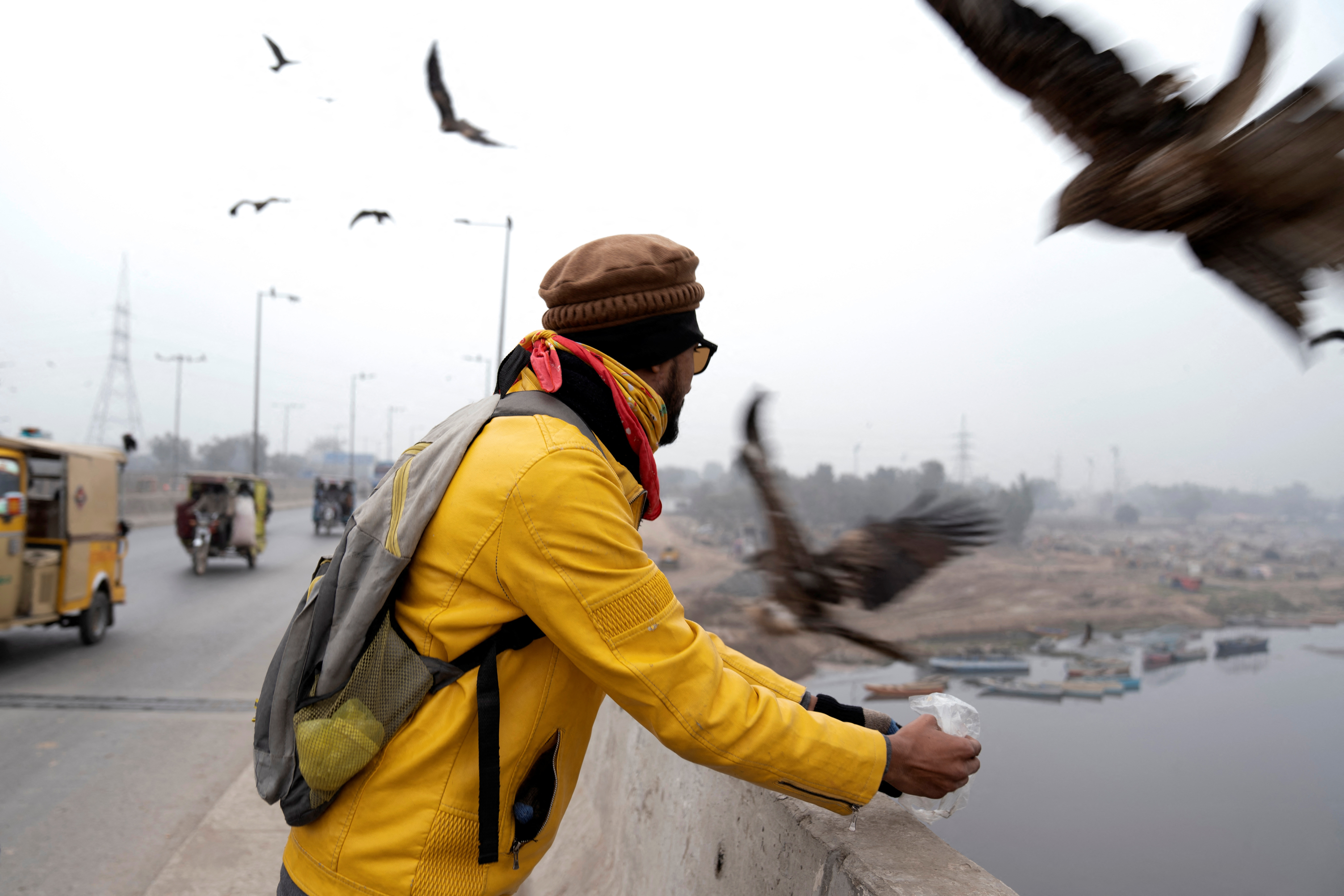 Khurram feeds leftover bread to kites along Ravi Bridge in Lahore