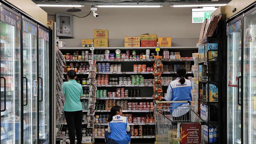 Staff stock canned food at a supermarket ahead of Typhoon Krathon which is expected to intensify and make an unusual landfall