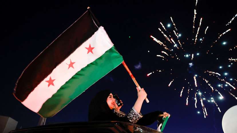 People celebrate after fighters of the ruling Syrian body ousted Syria's Bashar al-Assad, in Damascus