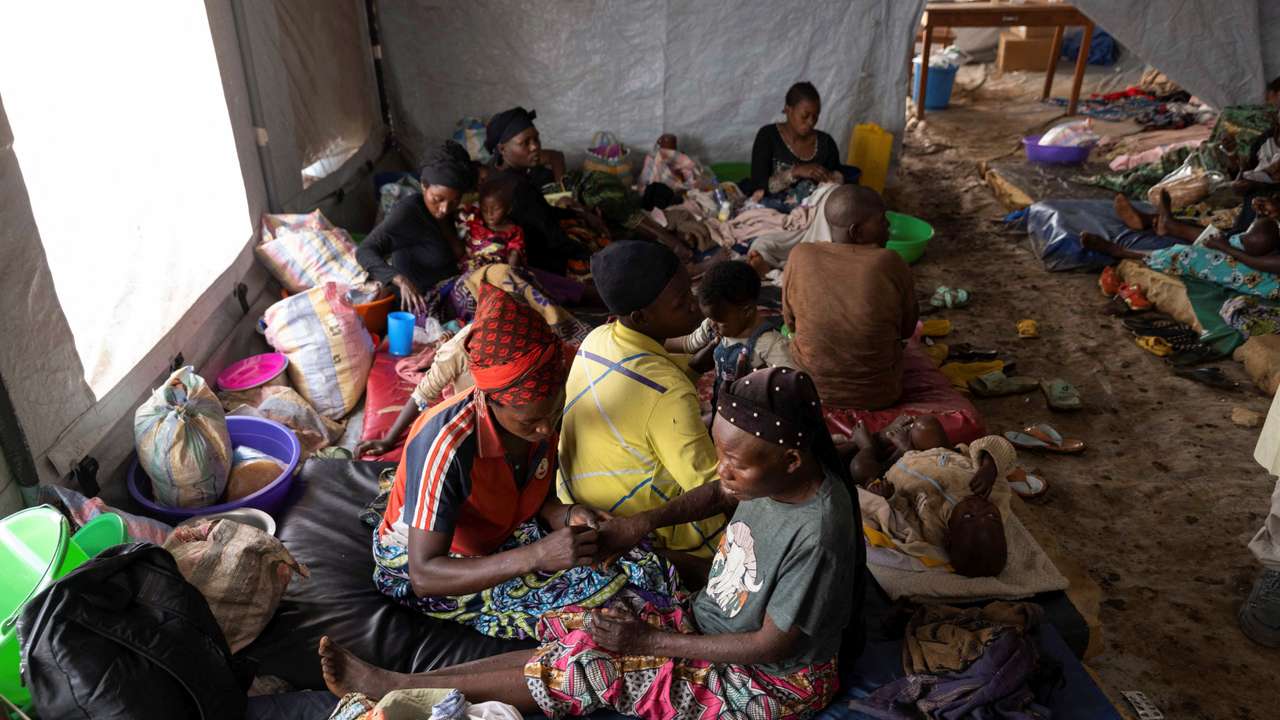 Nsimire Nakaziba pricks the rashes on her sister Sifa Mwakasisi to relieve pain inside a tent where she is undergoing treatment against mpox at the Kavumu hospital in Kabare territory