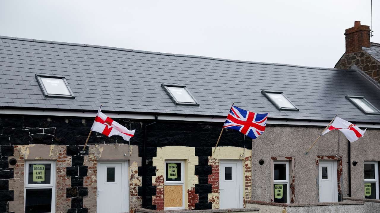 Signs reading: "Locals live here", are displayed on a residential house, in Ballymena