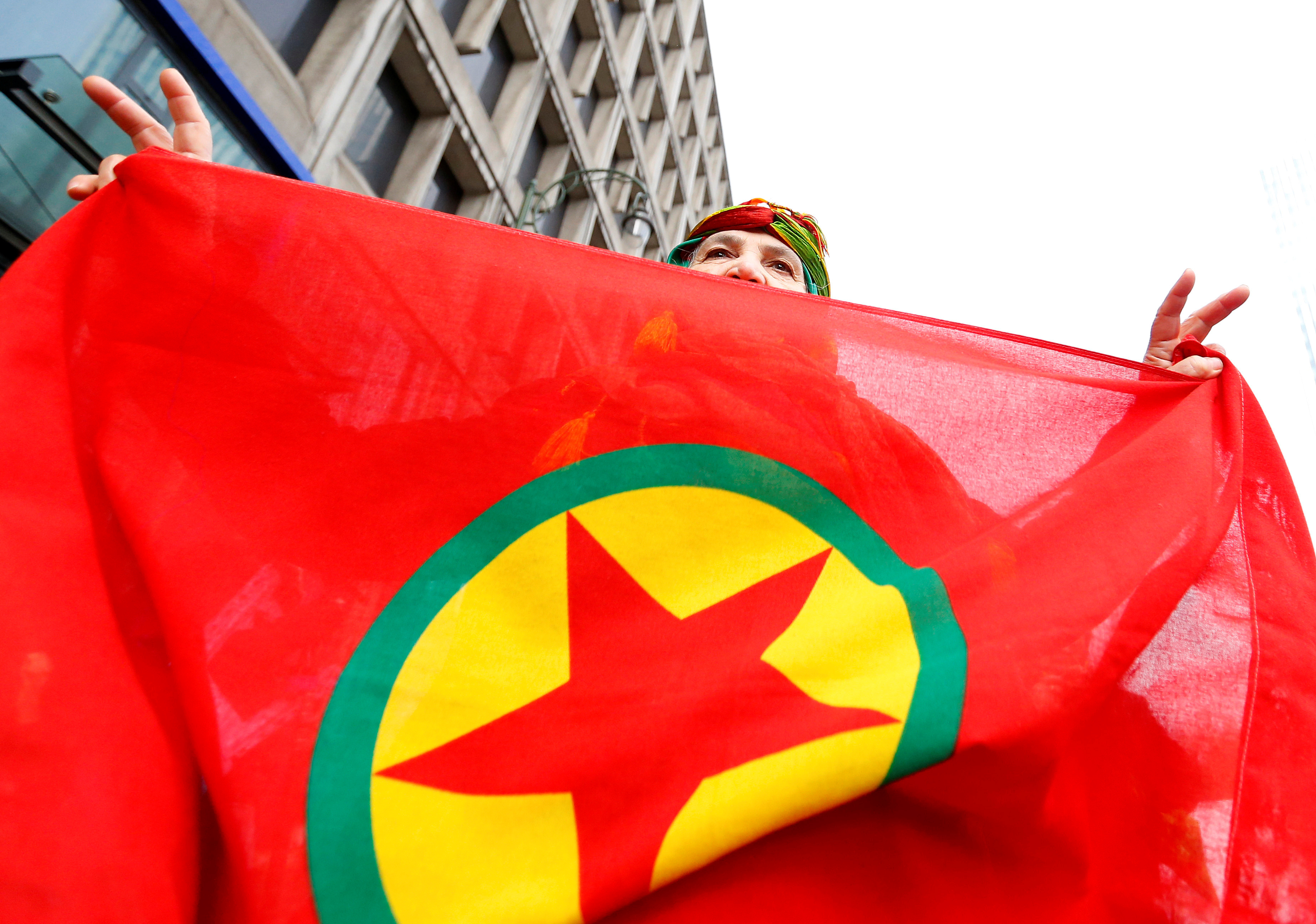 A woman holds a flag of the PKK during a demonstration against Turkish President Tayyip Erdogan in central Brussels