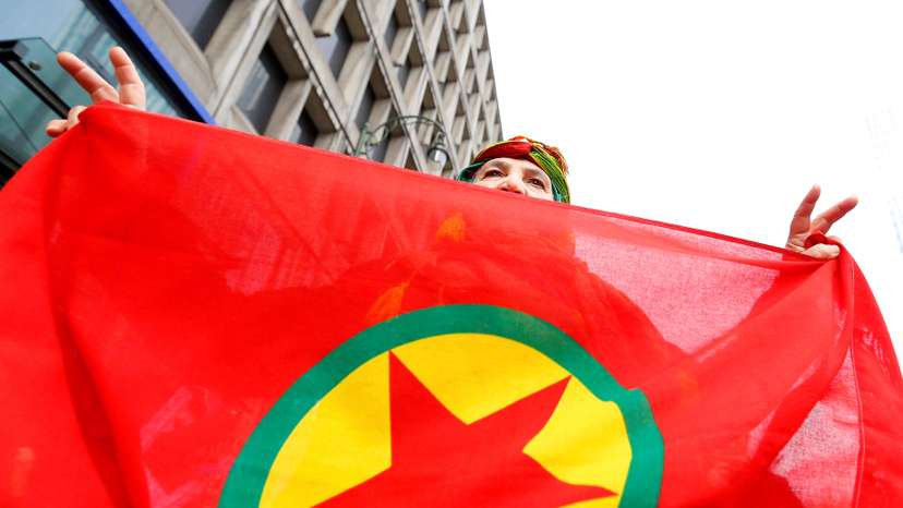 A woman holds a flag of the PKK during a demonstration against Turkish President Tayyip Erdogan in central Brussels