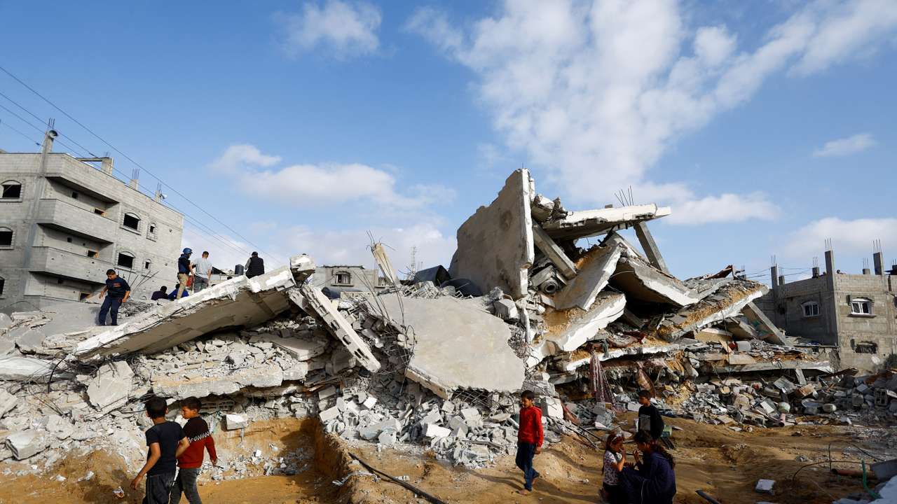 Palestinians inspect the site of an Israeli strike on a house, in Rafah