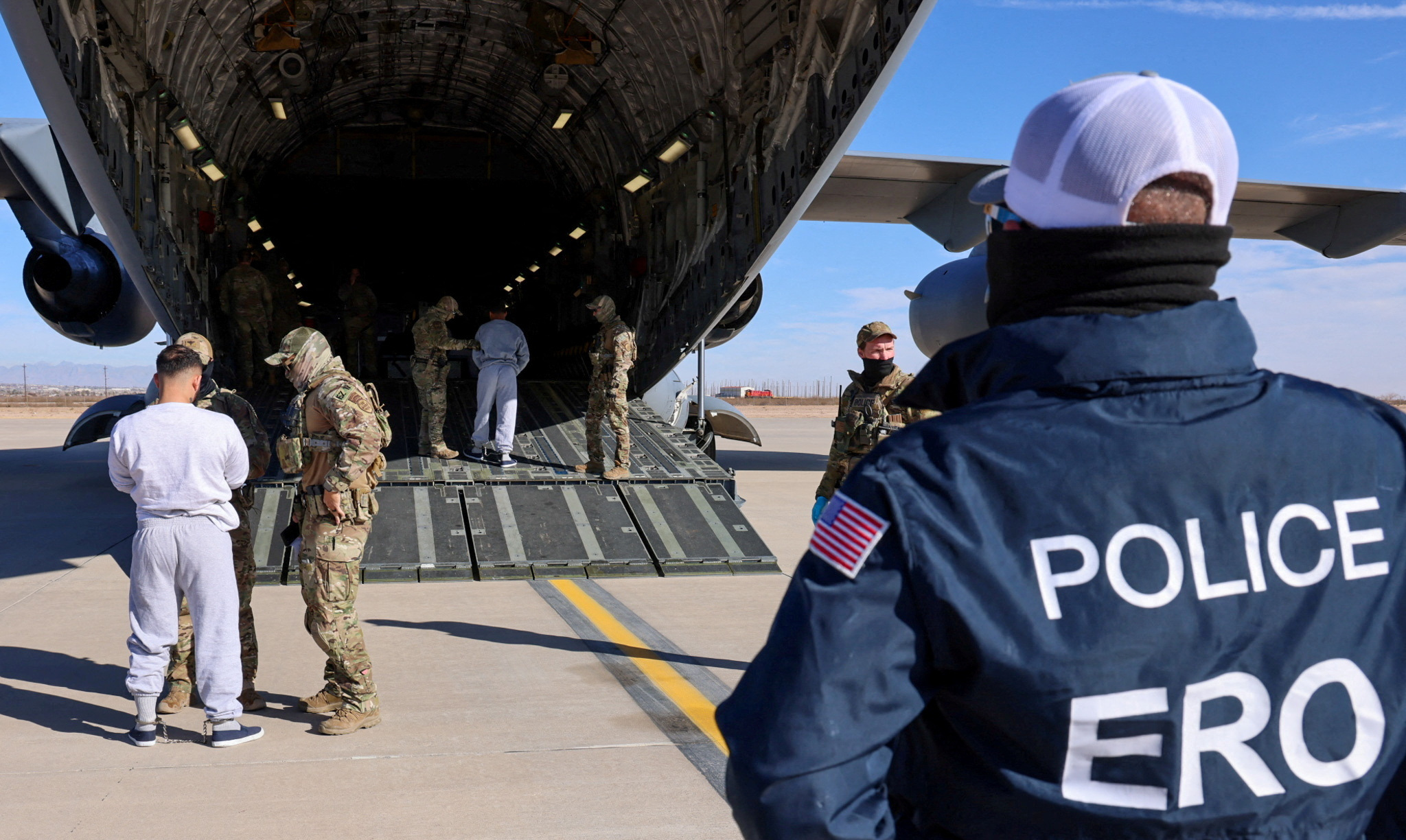 FILE PHOTO: The first U.S. military aircraft to carry detained migrants to Guantanamo Bay is boarded from an unspecified location in the U.S.