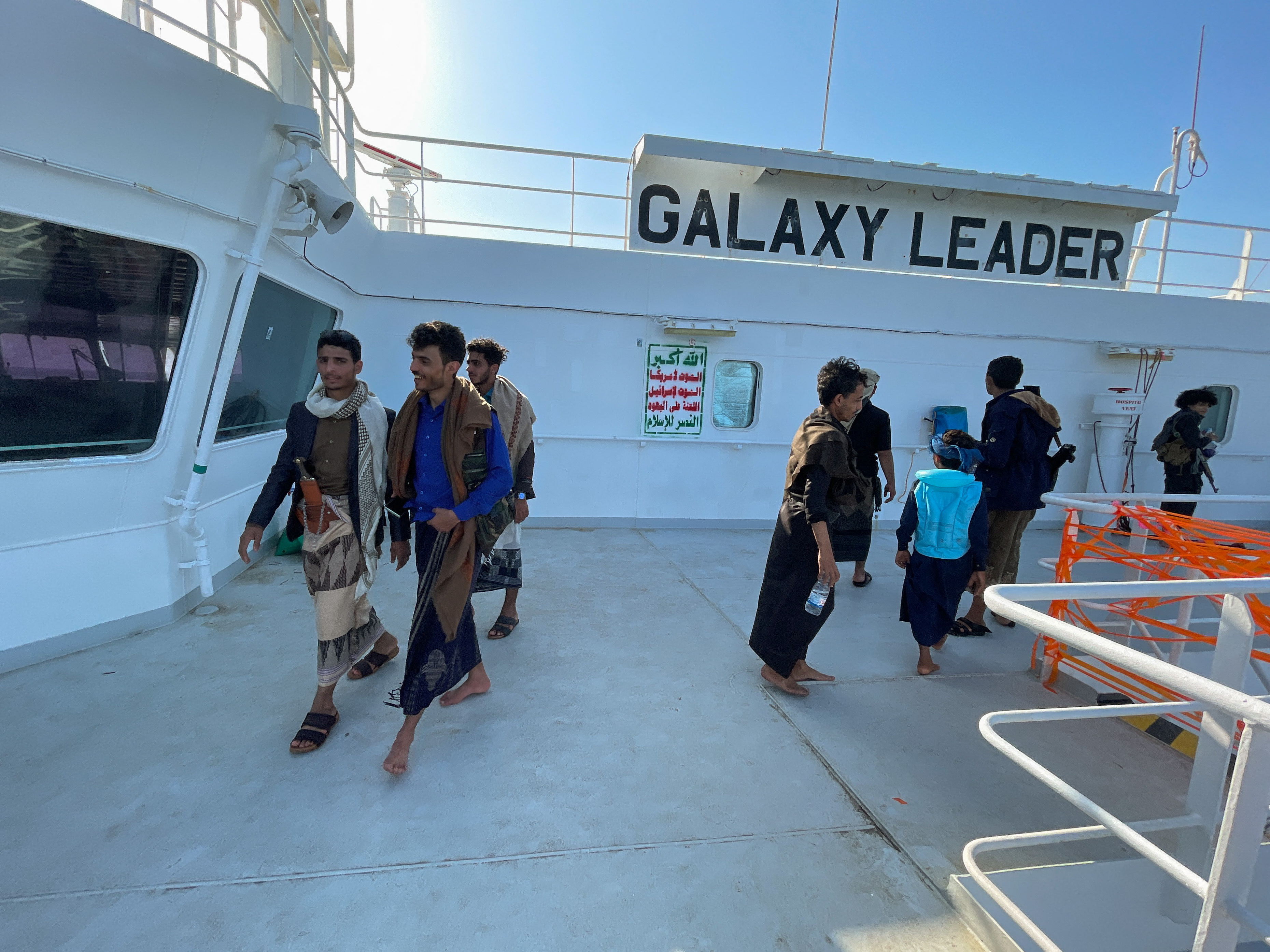 People tour the deck of the Galaxy Leader commercial ship, seized by Yemen's Houthis last month, off the coast of al-Salif