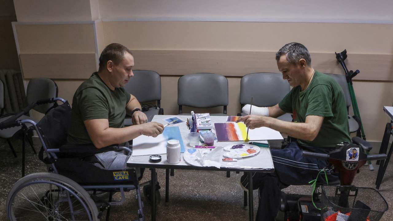Injured Ukrainian service members draw during an art therapy session at a medical centre in Vinnytsia