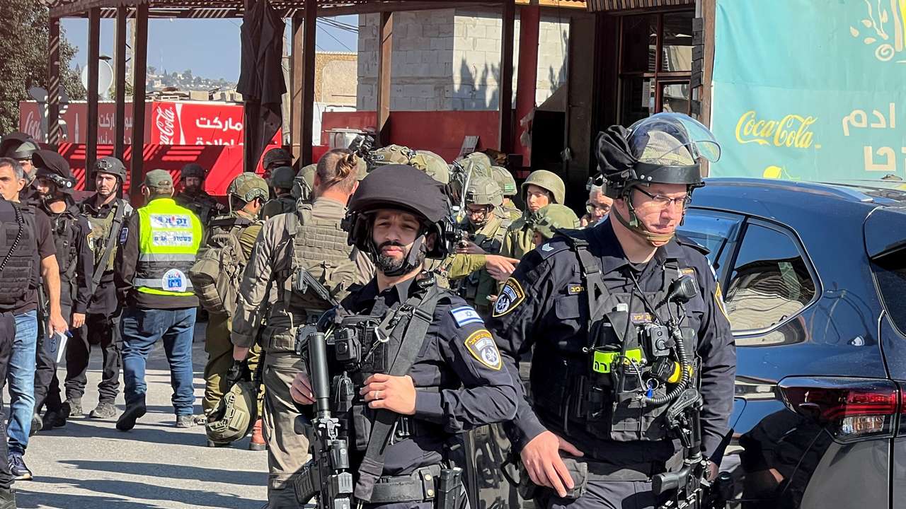Israeli security and rescue personnel at the scene of a shooting attack on a car and bus where at least three Israelis were killed near Kedumim in the Israeli-occupied West Bank