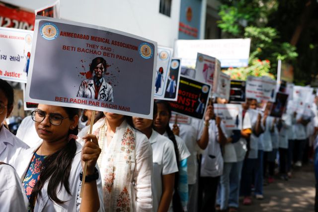 Resident doctors hold posters and shout slogans during a protest march, in Ahmedabad