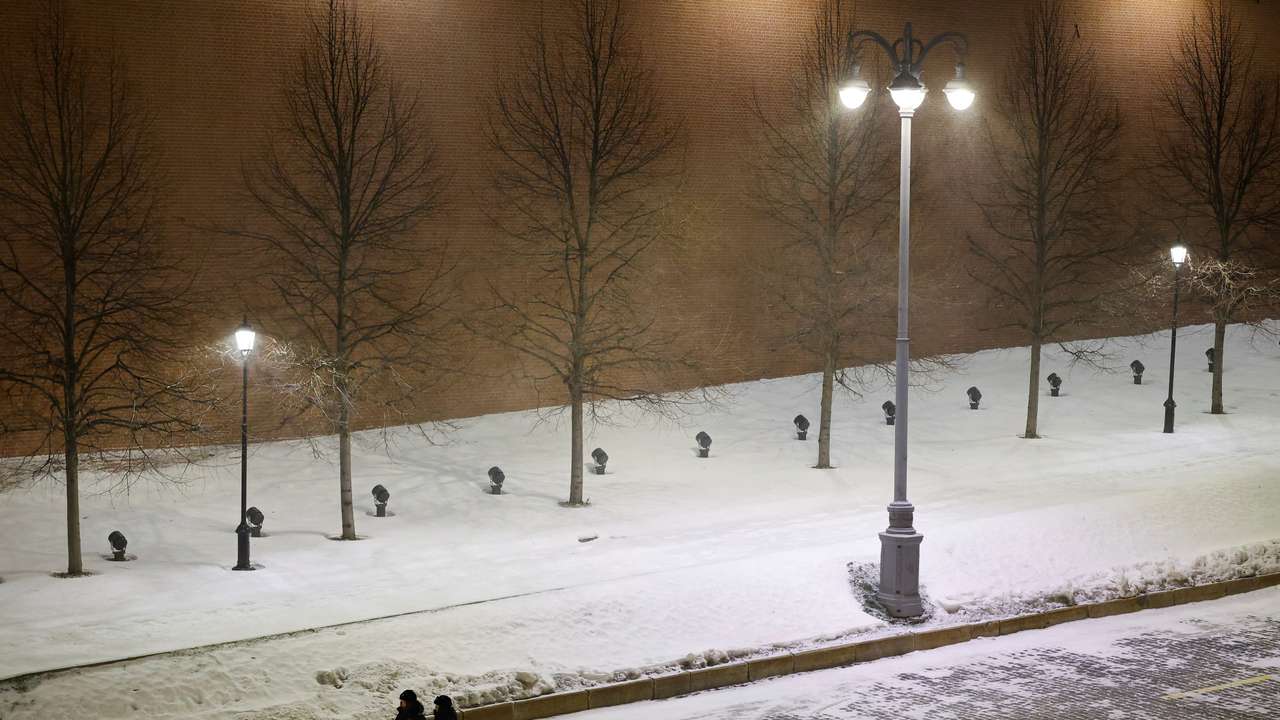 Law enforcement officers walk along the Kremlin wall during New Year's Eve celebrations in Moscow
