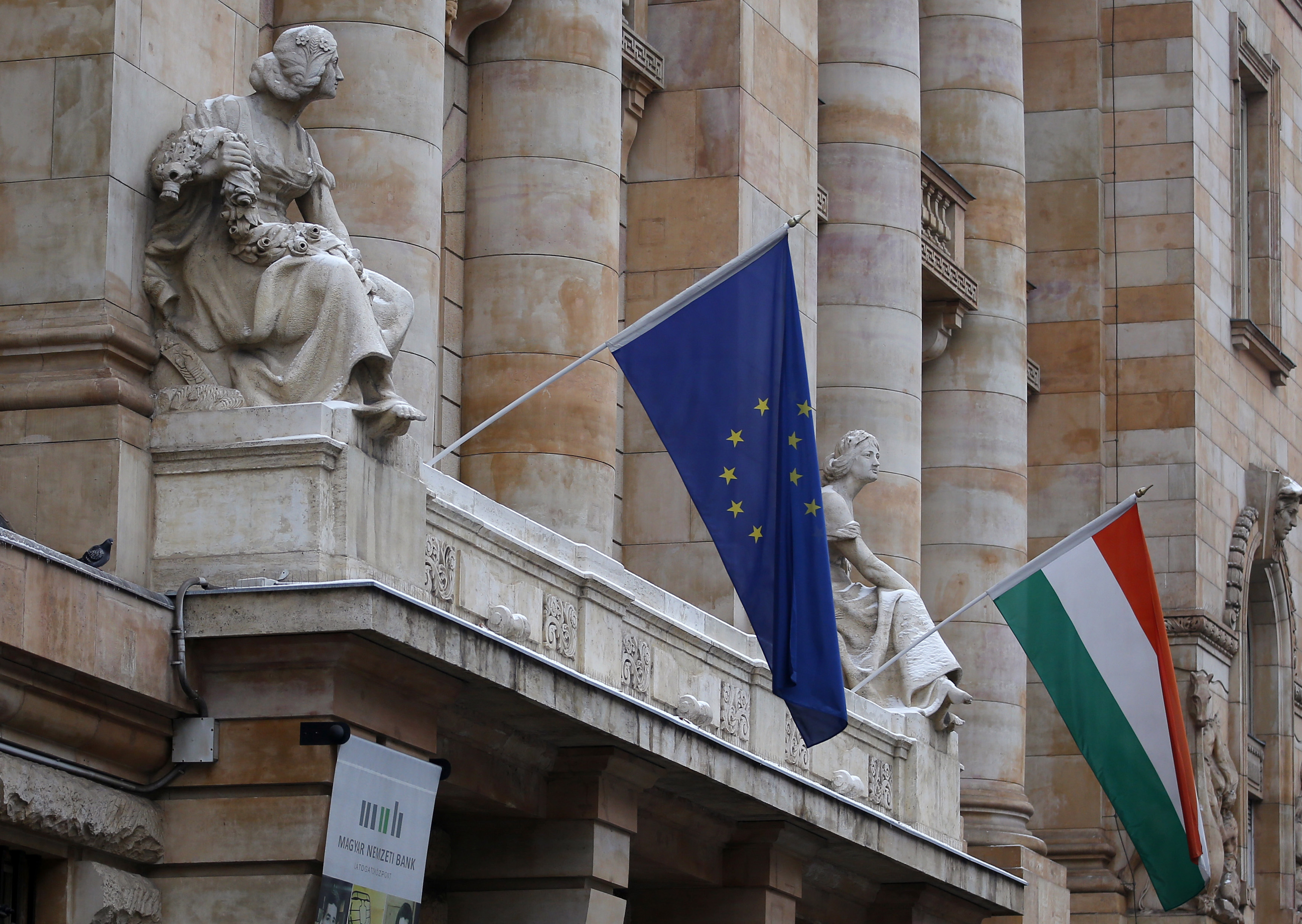 The Hungarian national flag and the flag of the European Union fly on the building of the National Bank of Hungary in Budapest
