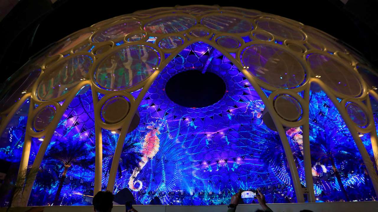 Delegates use their mobile phones to record the projections at the Al Wasl Dome at the Dubai's Expo City during the United Nations Climate Change Conference (COP28) in Dubai