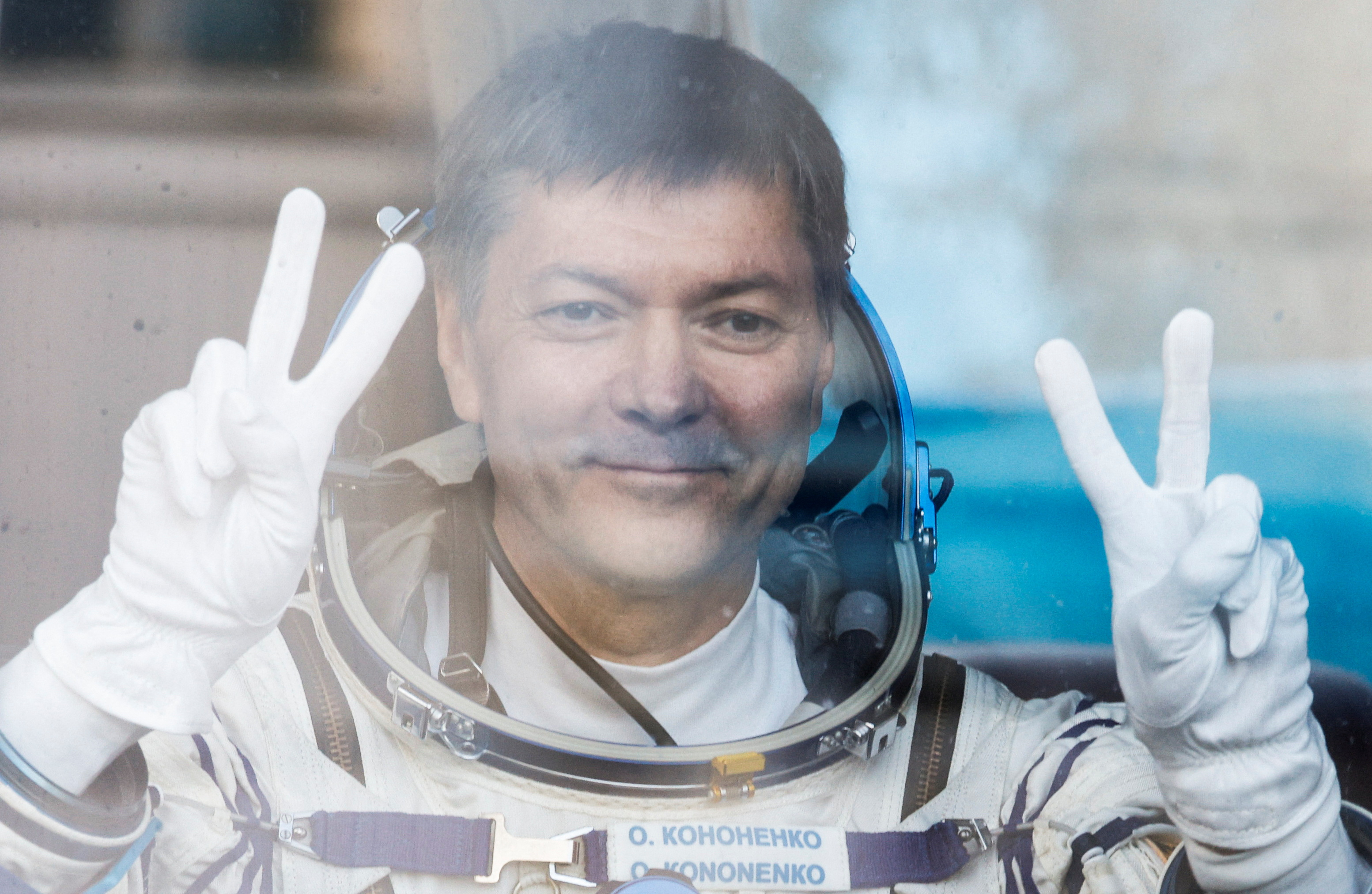 FILE PHOTO: Roscosmos cosmonaut Kononenko reacts in the bus just before the departure to the launchpad at the Baikonur Cosmodrome