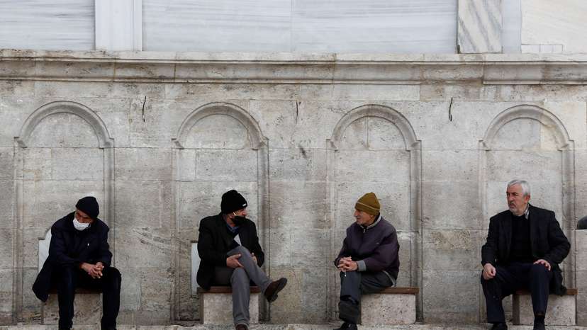 FILE PHOTO: Men rest at the courtyard of Fatih Mosque in Istanbul,
