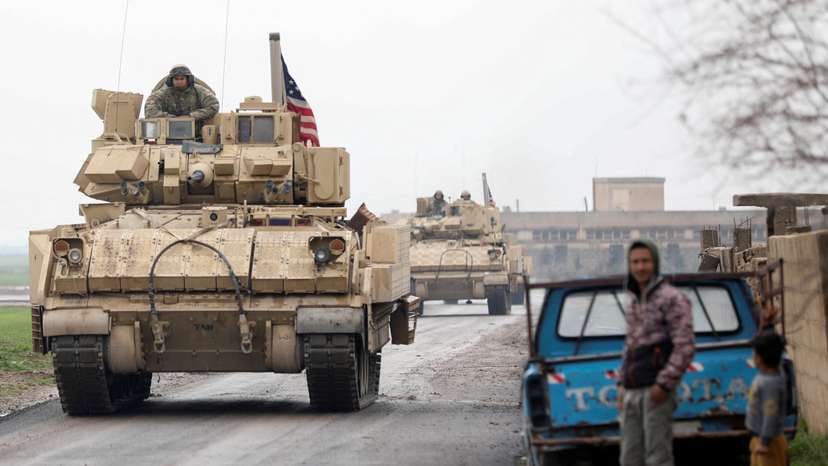 Residents stand on a street during a joint U.S.- Kurdish-led Syrian Democratic Forces (SDF) patrol in the countryside of Qamishli