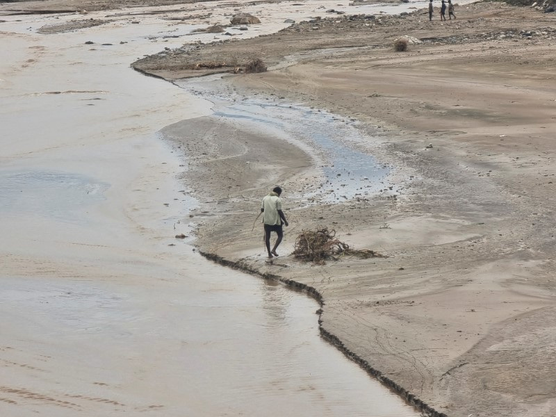 Man walks near flood water following heavy rains in Hajjah