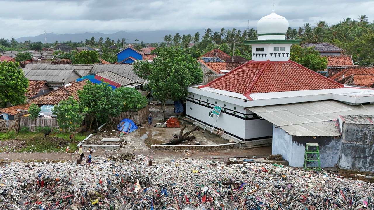 Indonesian fishing village grapples with piles of trash amid erratic high tides