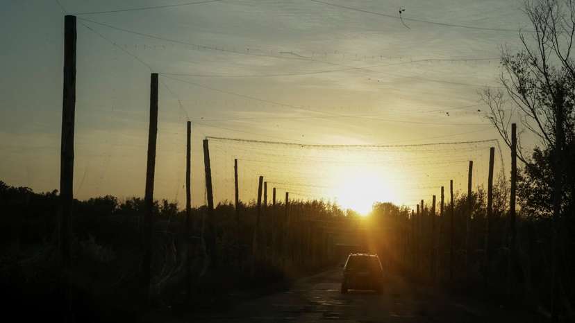 A car drives along a road covered with anti-drone net near the frontline town of Kupiansk
