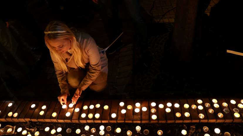 A woman lights a candle during a commemoration of the first anniversary of the October 7 Hamas attacks on Israel at the the Dohany Street Synagogue in Budapest