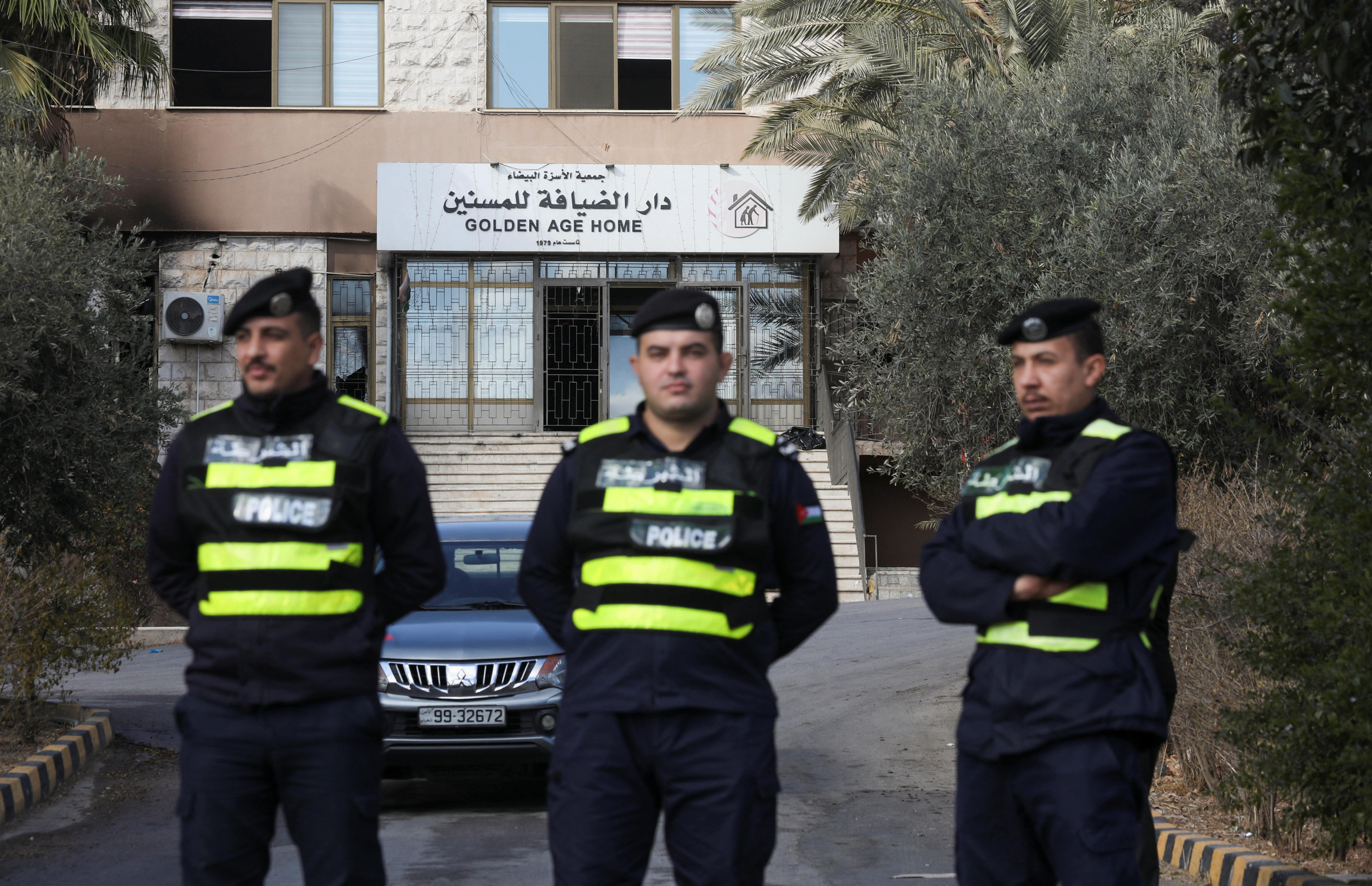 Jordanian police officers stand guard, after a fire broke out early on Friday at a private elderly care center in the Jordanian capital Amman