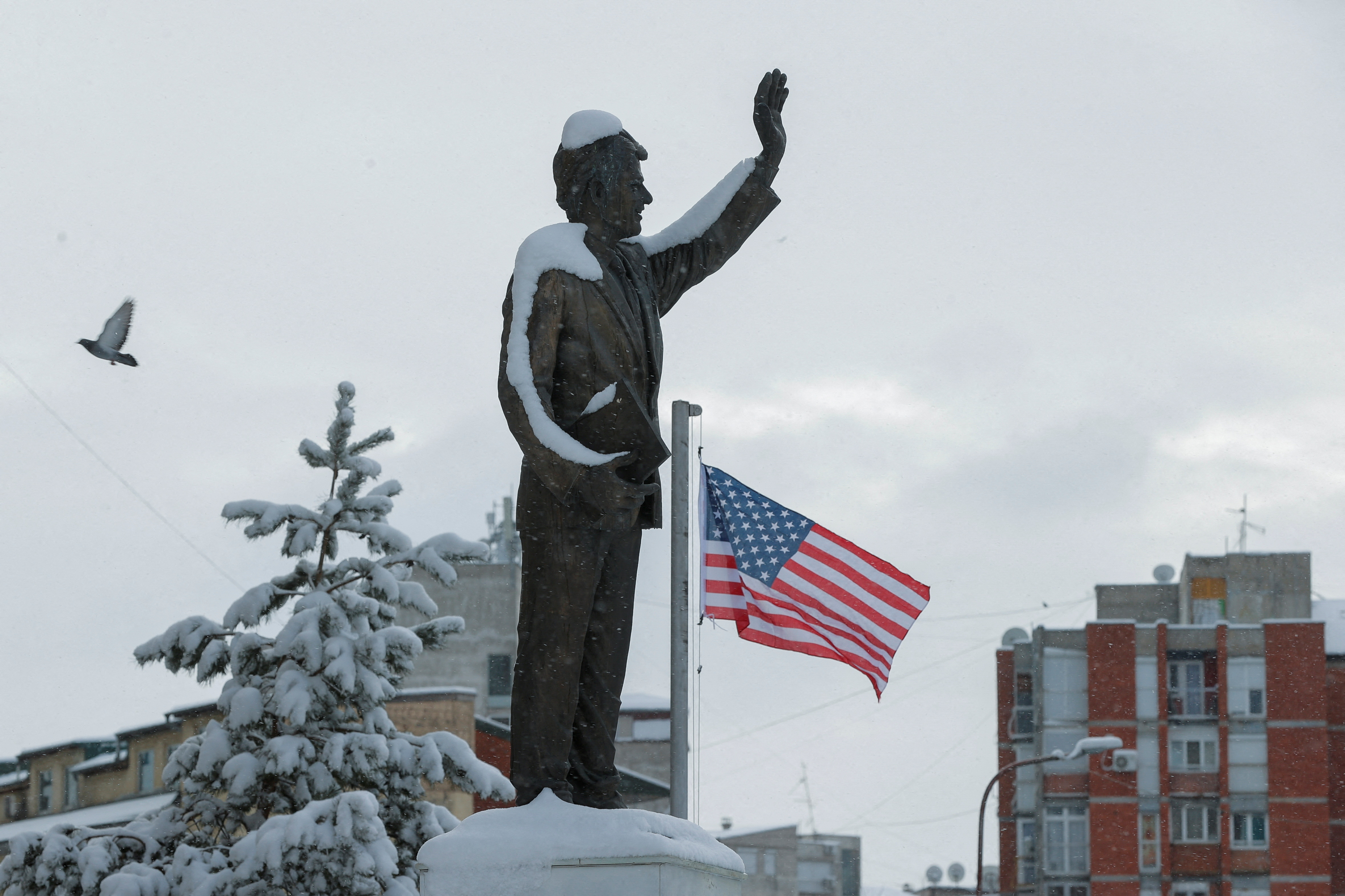 A statue of former U.S. President Bill Clinton is covered by snow, in Pristina