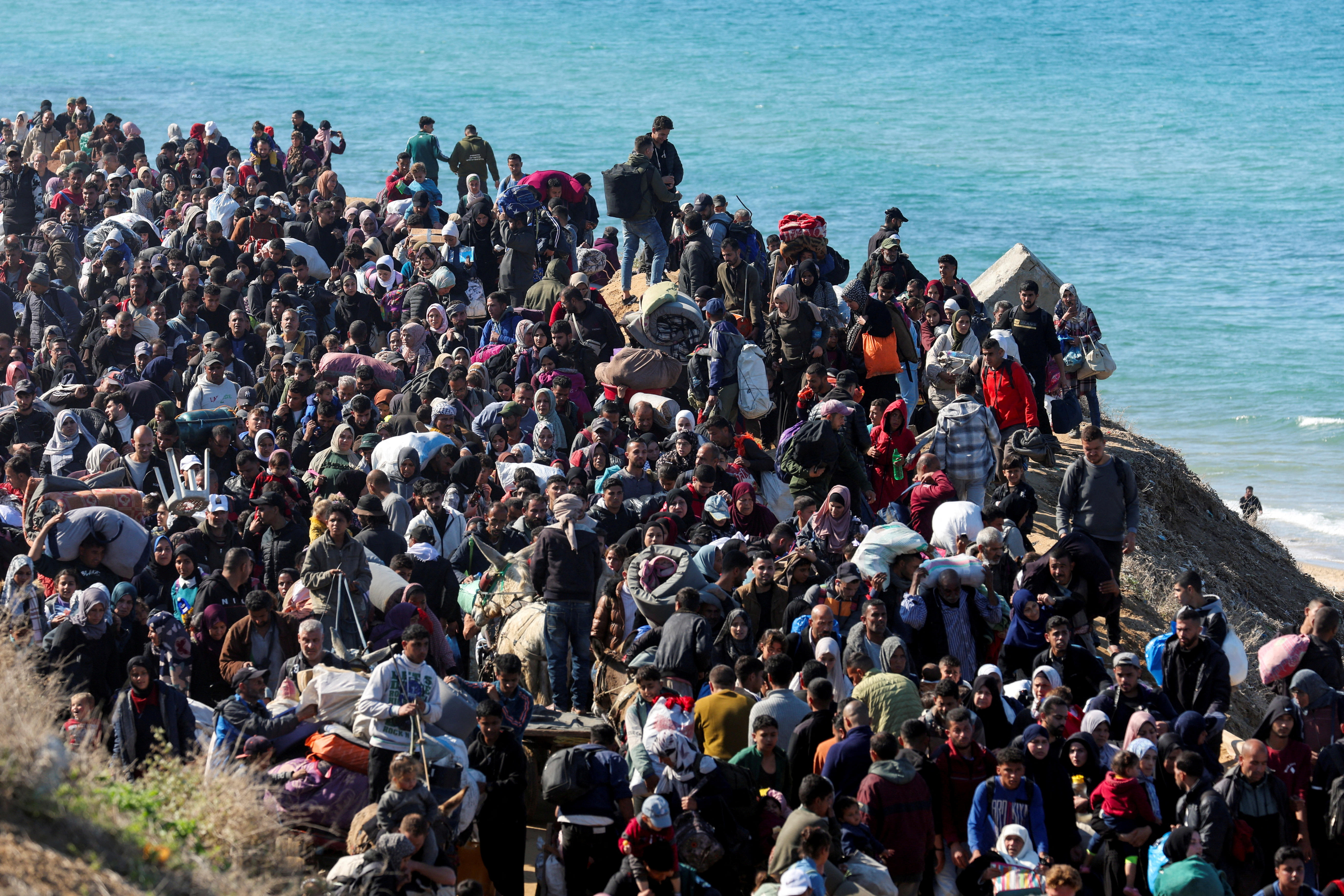 FILE PHOTO: Displaced Palestinians make their way back to their homes in northern Gaza, amid a ceasefire between Israel and Hamas, in the central Gaza Strip