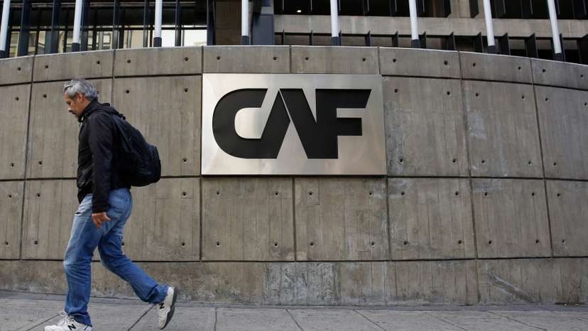 A man walks past the corporate logo of the Development Bank of Latin America at its headquarters in Caracas