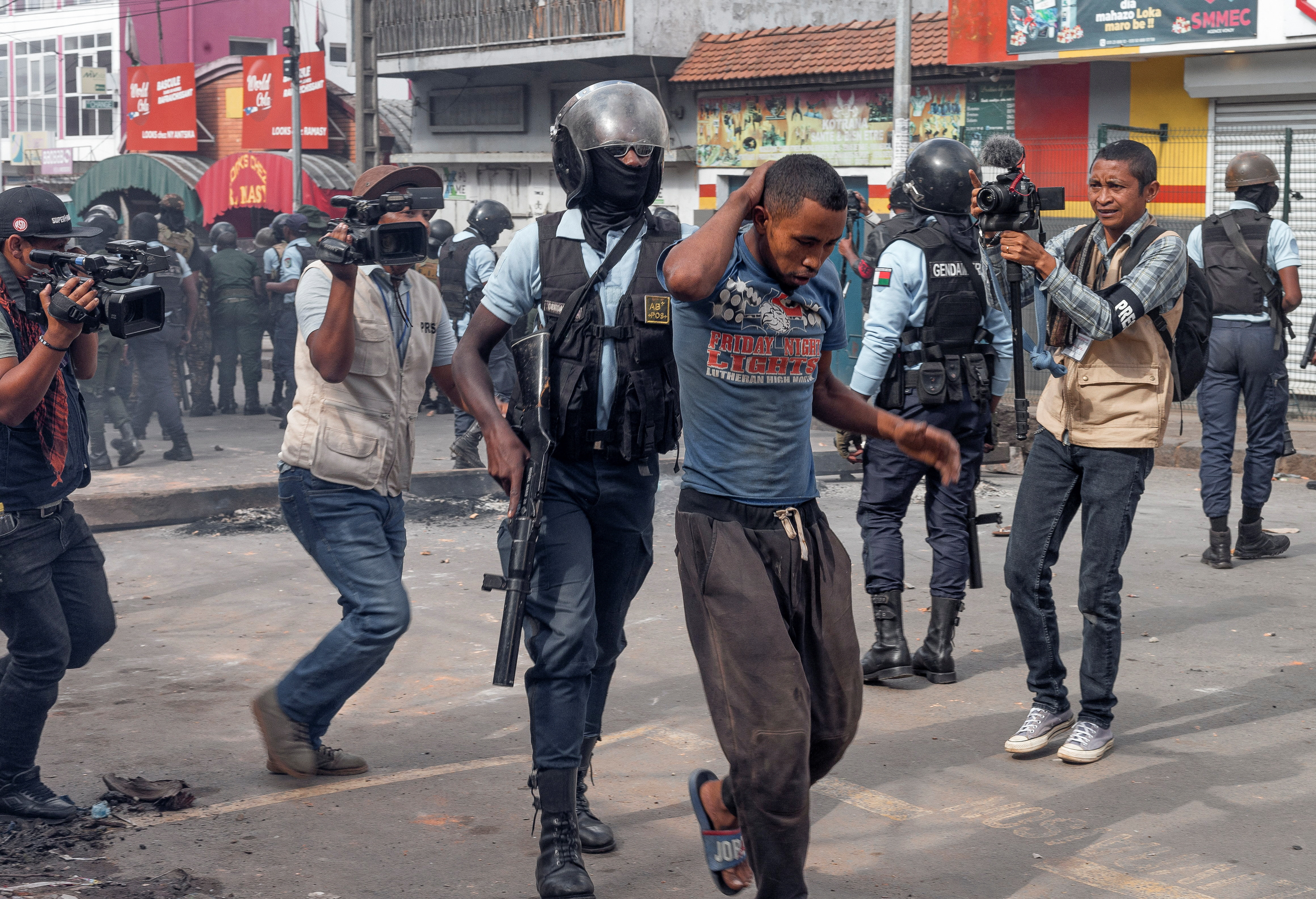 A riot police officer detains a supporter of the opposition parties during a protest ahead of the forthcoming first round of Madagascar's presidential election in Antananarivo