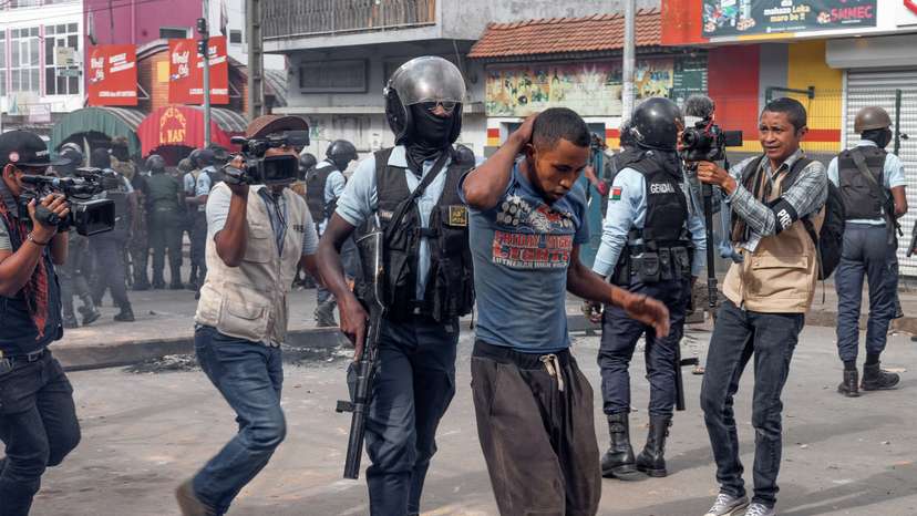 A riot police officer detains a supporter of the opposition parties during a protest ahead of the forthcoming first round of Madagascar's presidential election in Antananarivo