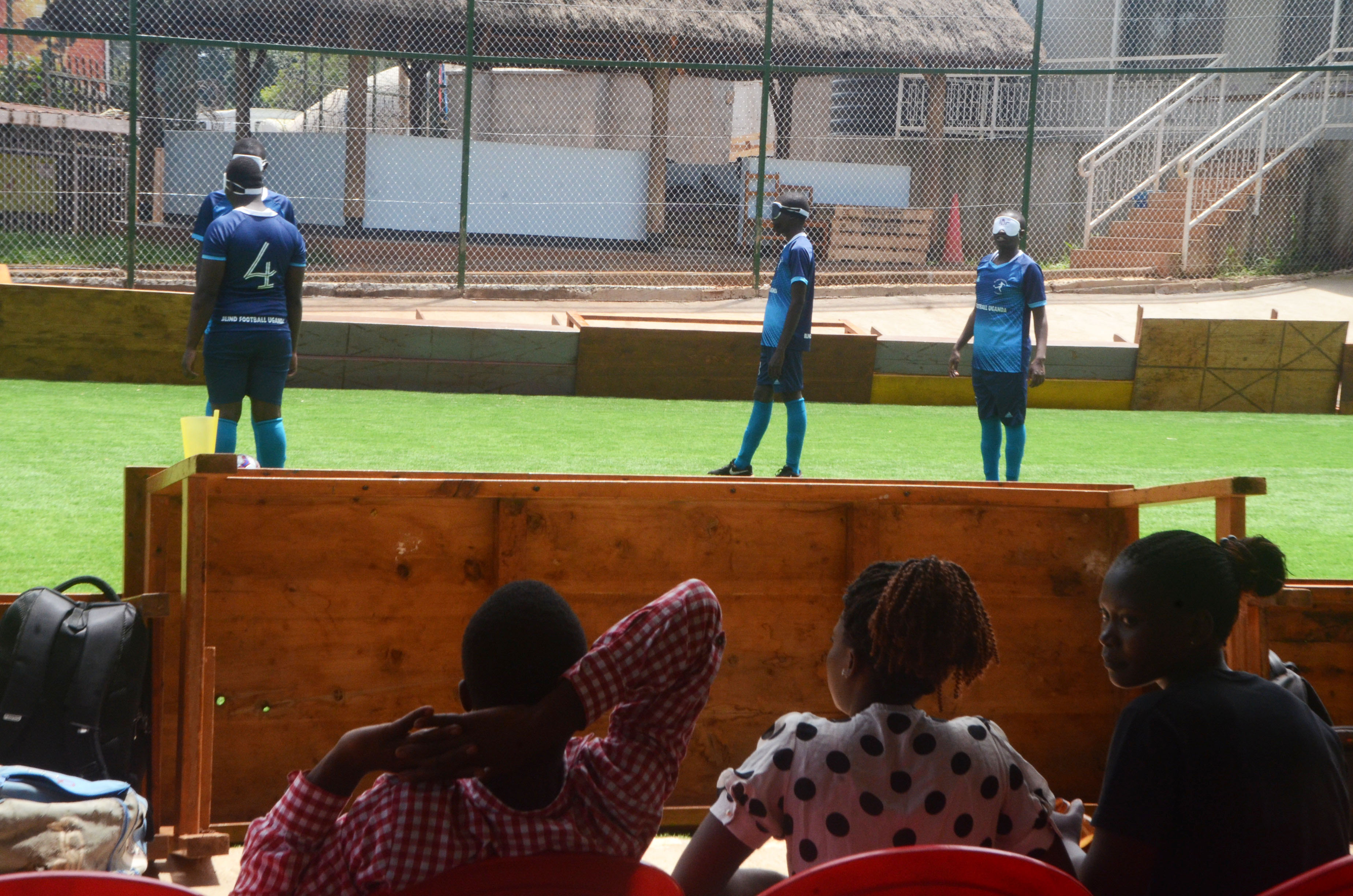 people watch blind football players compete during a match