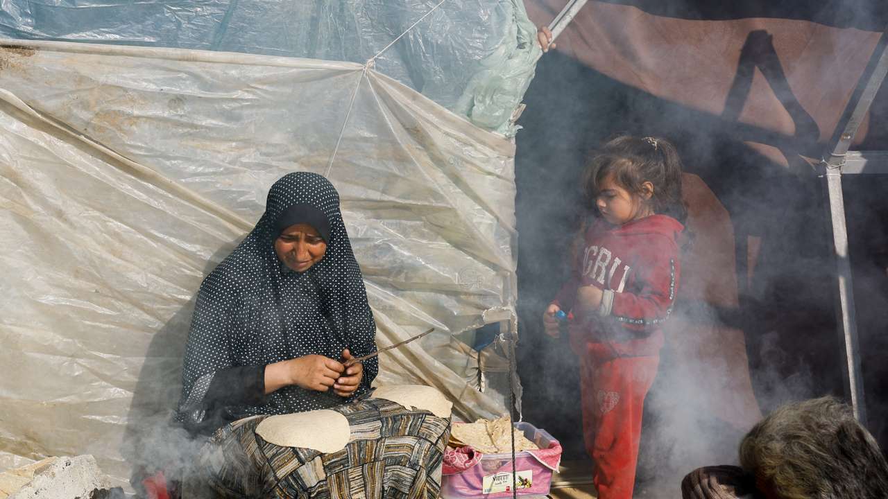 Displaced Palestinians, who fled their houses due to Israeli strikes, shelter in a tent camp near the border with Egypt, in Rafah