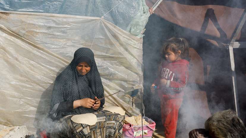 Displaced Palestinians, who fled their houses due to Israeli strikes, shelter in a tent camp near the border with Egypt, in Rafah