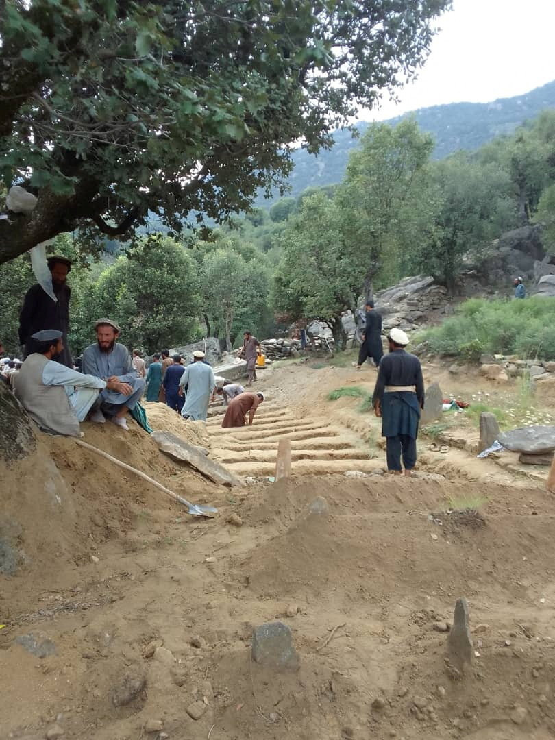 Afghan men dig graves for the people who died during a deadly magnitude-6 earthquake, at Sepero Village, Chawkay district, in Kunar