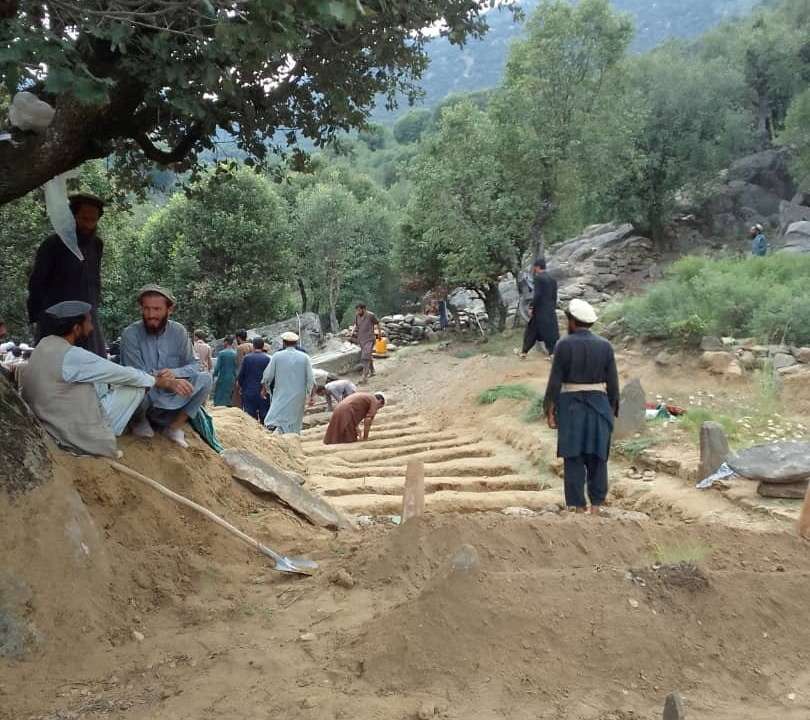 Afghan men dig graves for the people who died during a deadly magnitude-6 earthquake, at Sepero Village, Chawkay district, in Kunar