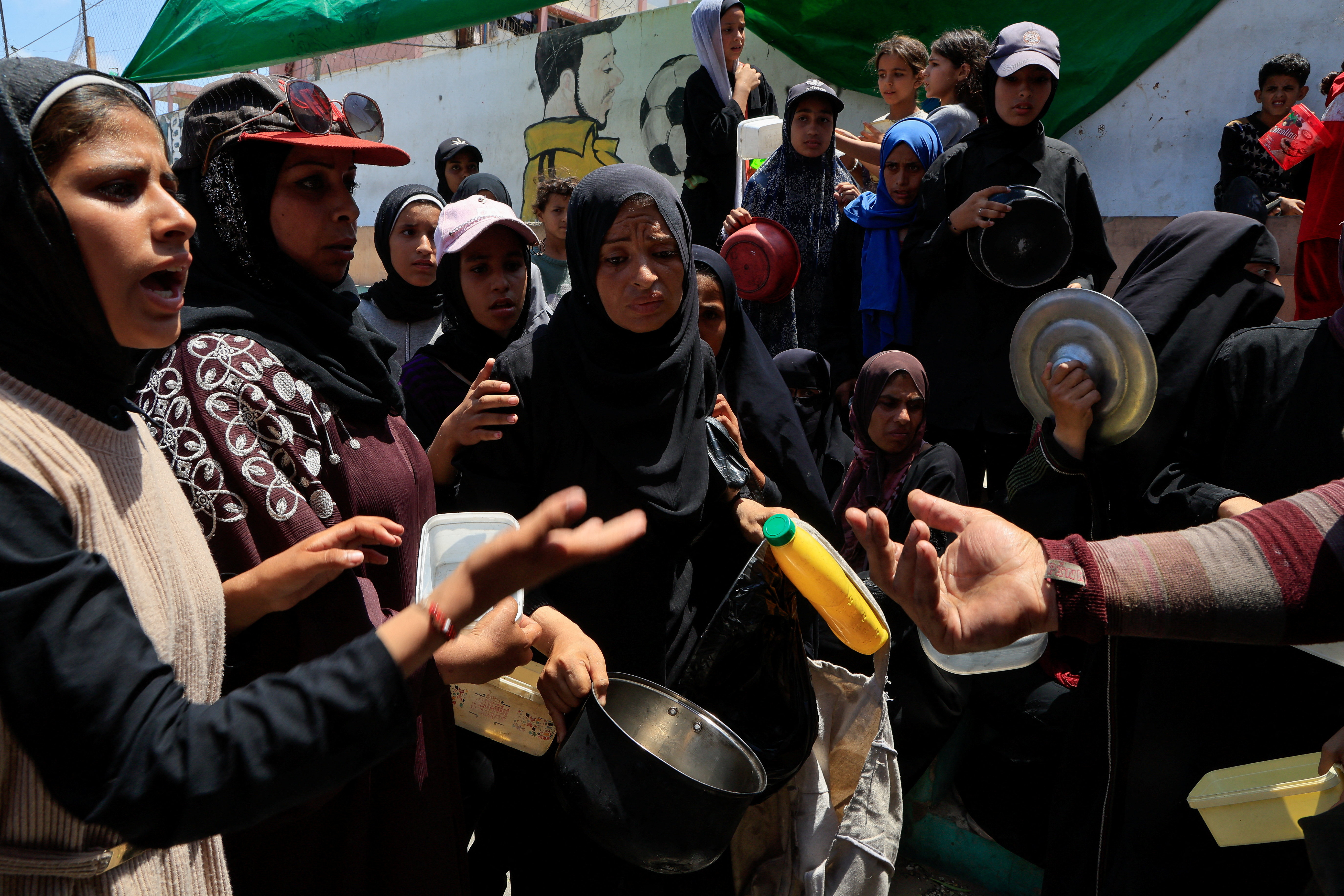 Palestinians gather to receive food from a charity kitchen in Nuseirat