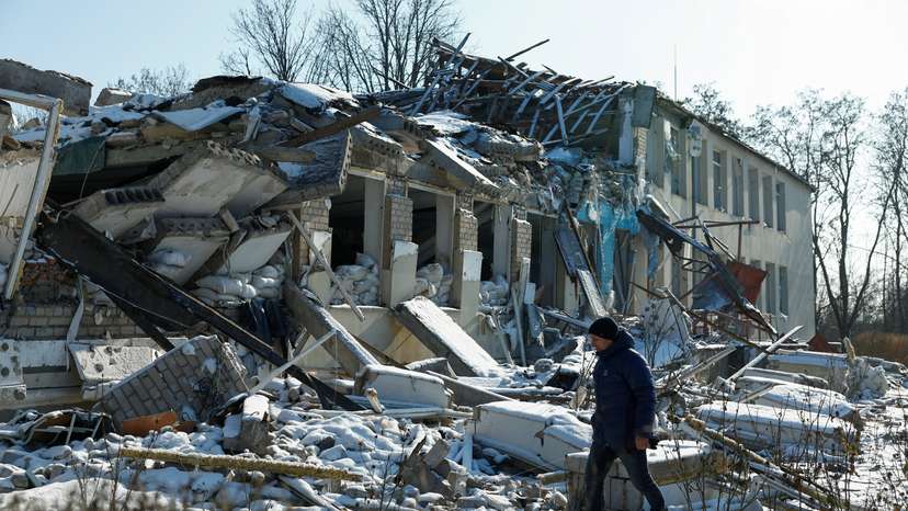 Director of a local lyceum Yurii Bilyk walks next to its building destroyed by a recent Russian air strike in the village of Novopavlivka