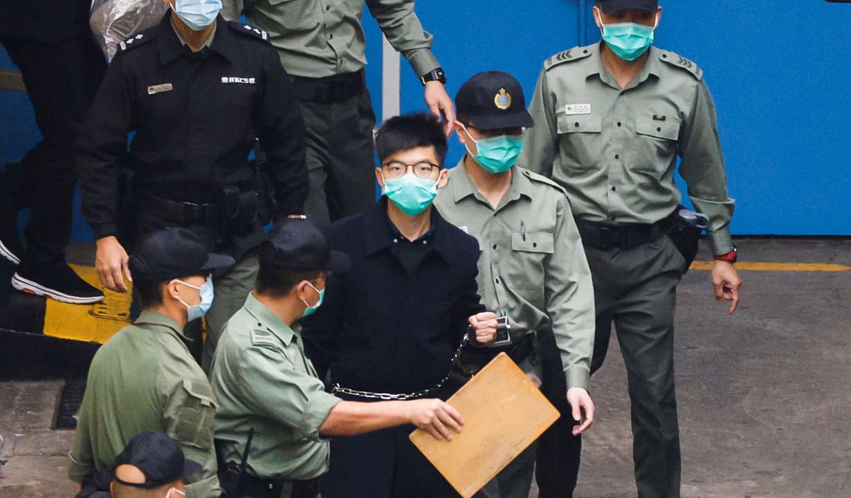 FILE PHOTO: Pro-democracy activist Joshua Wong walks to a prison van to head to court with other activists, over a national security law charge, in Hong Kong