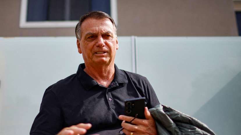 FILE PHOTO: Former Brazilian President Jair Bolsonaro gestures while standing in front of his house before testifying to the Federal Police in Brasilia
