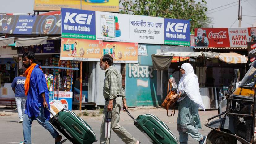 People carry baggage as they travel towards the Attari-Wagah crossing on the India-Pakistan border near Amritsar