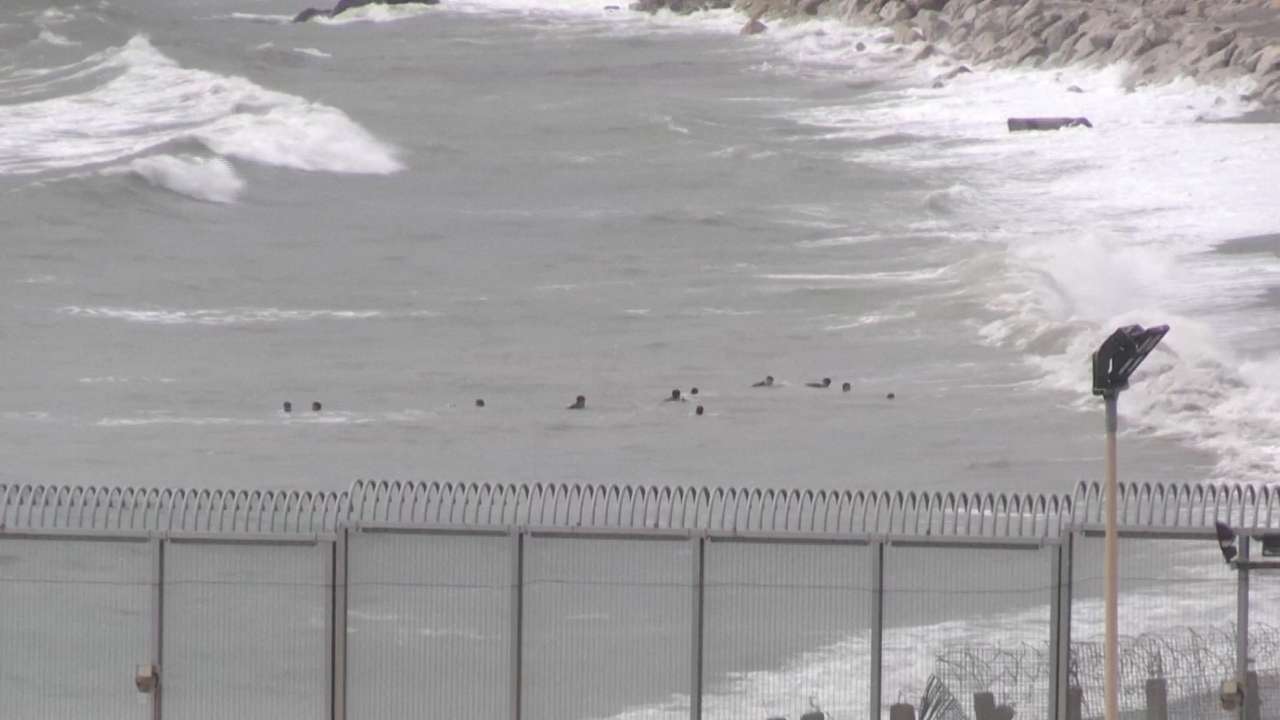 A view shows migrants swimming towards the shore on Moroccan side of border, in Ceuta