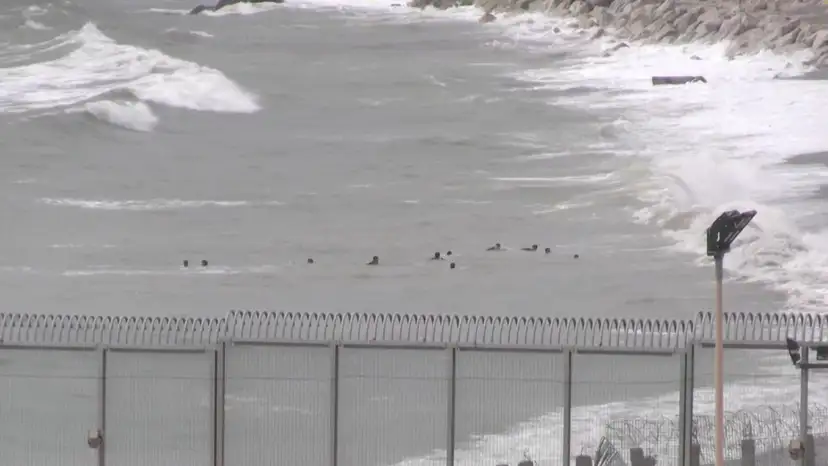A view shows migrants swimming towards the shore on Moroccan side of border, in Ceuta