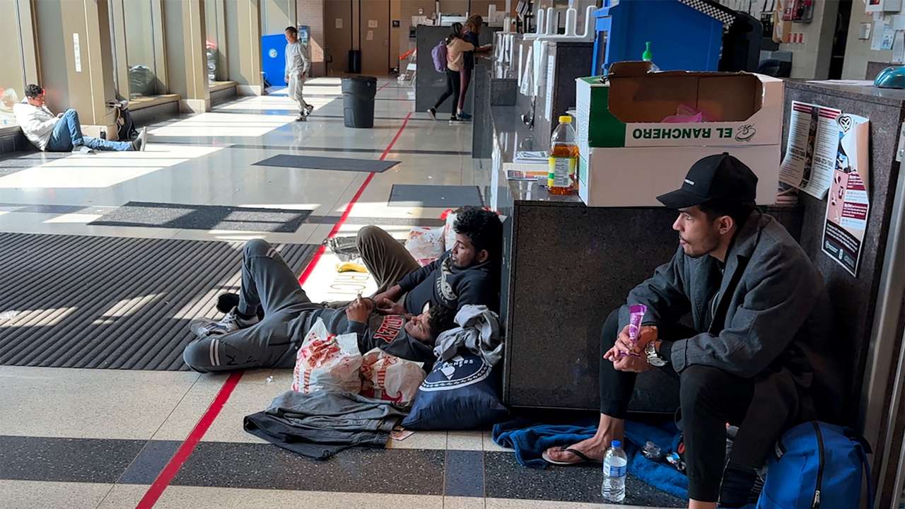 Migrants seek shelter inside the District 12 station of the Chicago Police Department in Chicago
