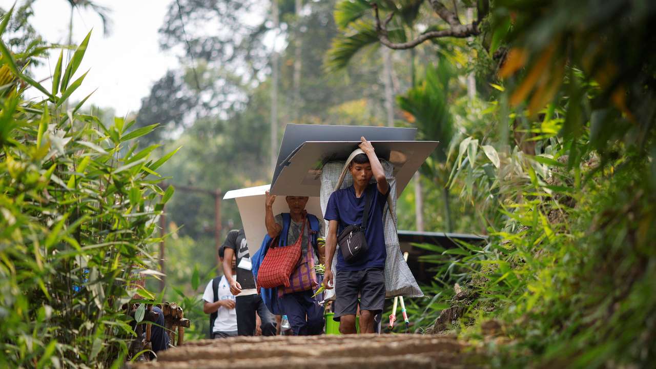 Polling officers and porters carry VVPAT and EVM to a remote village in Shillong