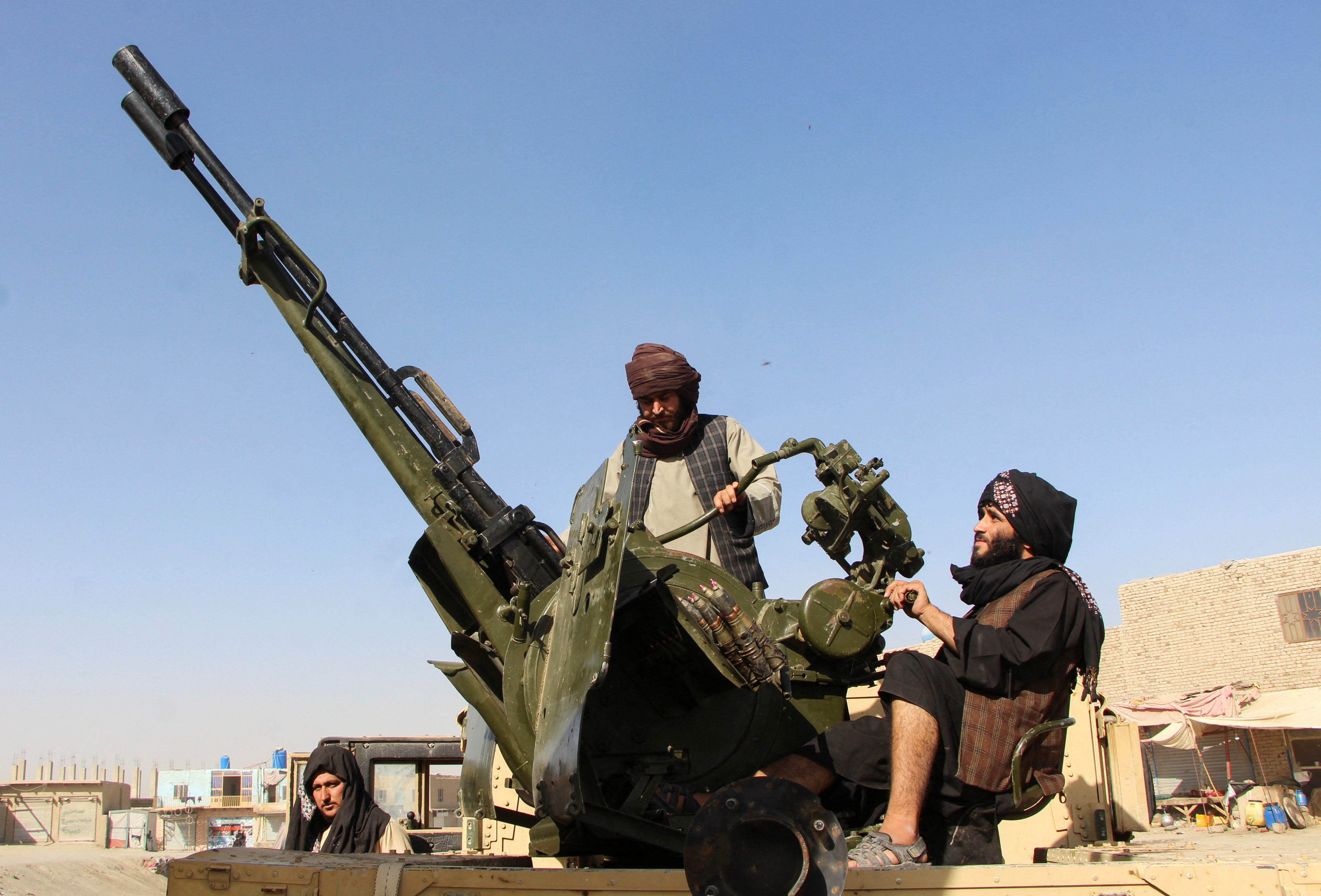 An Afghan Taliban fighter sit next to an anti-aircraft gun near the Afghanistan-Pakistan border in Spin Boldak, Kandahar Province, following exchanges of fire between Pakistani and Afghan forces