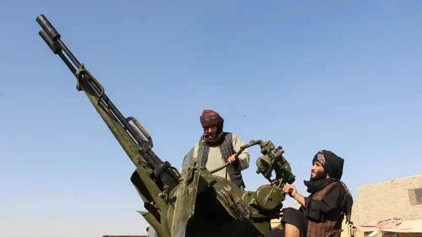 An Afghan Taliban fighter sit next to an anti-aircraft gun near the Afghanistan-Pakistan border in Spin Boldak, Kandahar Province, following exchanges of fire between Pakistani and Afghan forces