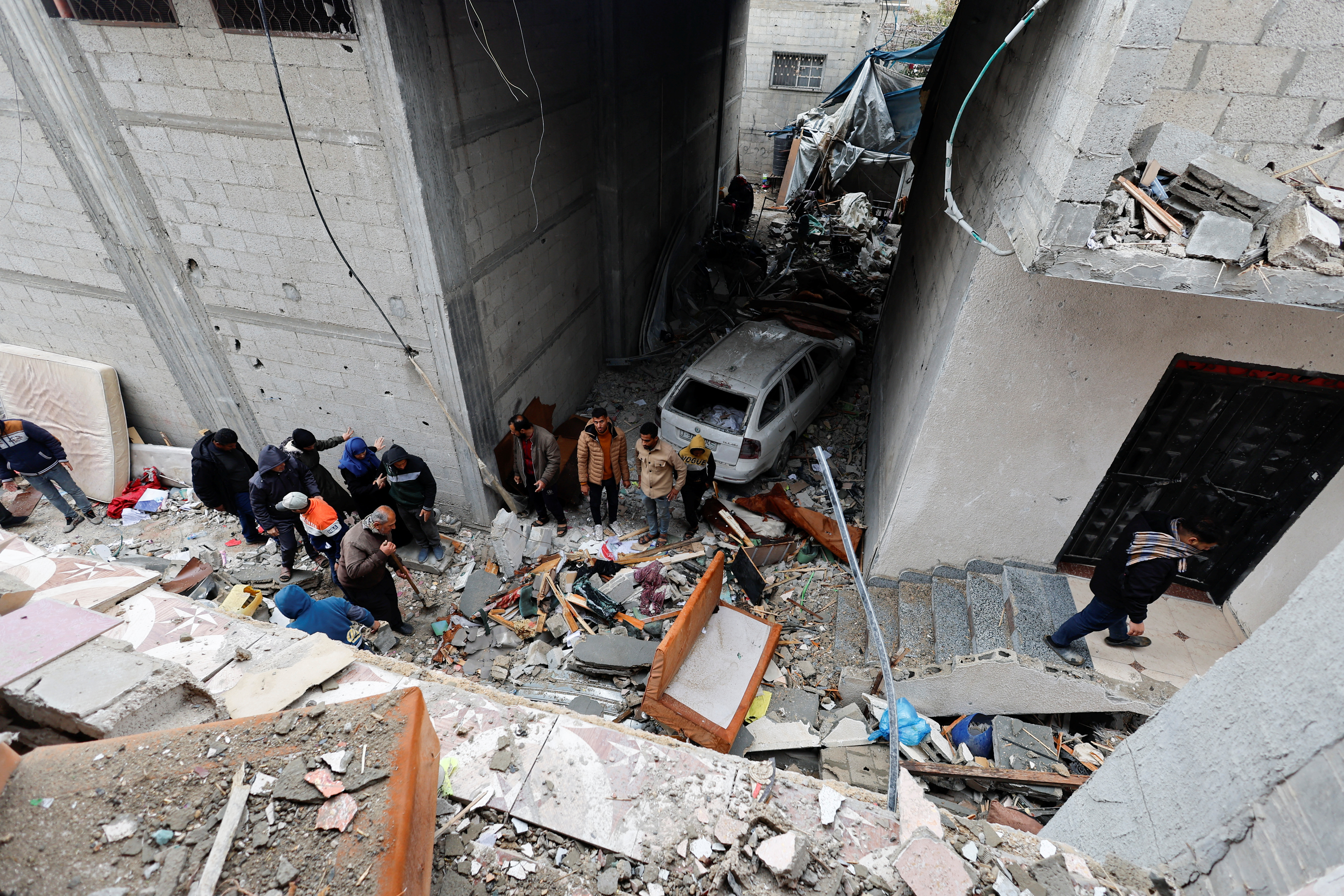 Palestinians inspect the site of an Israeli strike on a house in Rafah
